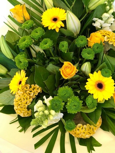 Hand tied in fresh lemon and green tones,including lily, roses, snapdragons, celosia and chrysanthemums. 