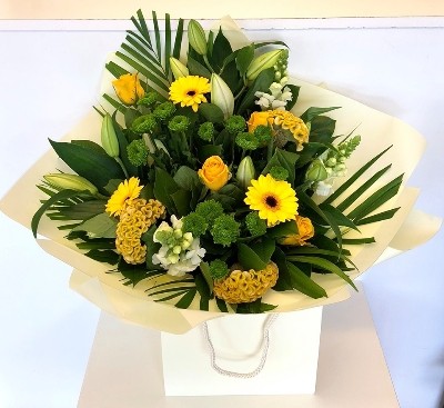 Hand tied in fresh lemon and green tones,including lily, roses, snapdragons, celosia and chrysanthemums. 