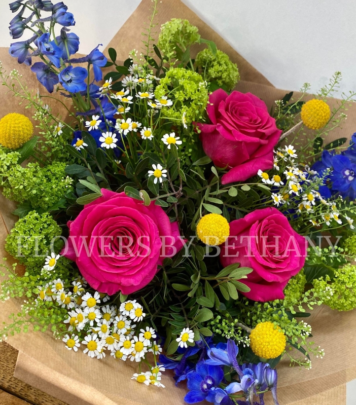 Make someone's day with this groovy bunch filled with roses, delphinium, craspedia, matricaria & more! 