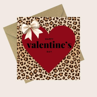 Valentine’s Day card with leopard print background, large red heart, satin-style ivory bow and the text Happy Valentine’s Day, paired with a kraft envelope.