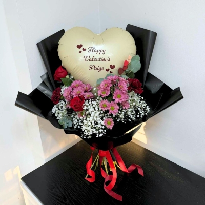 Large Valentine’s bouquet with red roses, pink flowers, gypsophila and eucalyptus in black wrap with red ribbon, created out of water to place into your own vase, featuring a personalised heart-shaped balloon arranged within the bouquet.