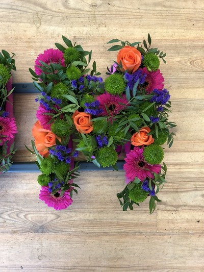 Stunning vibrant mixed letter MUM funeral tribute including roses, germini, orchids and chrysanthemum mix. 