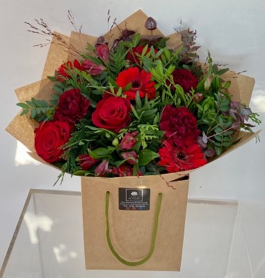 Roses, germini, carnation and alstroemeria with complimentary foliage to finish the design. 