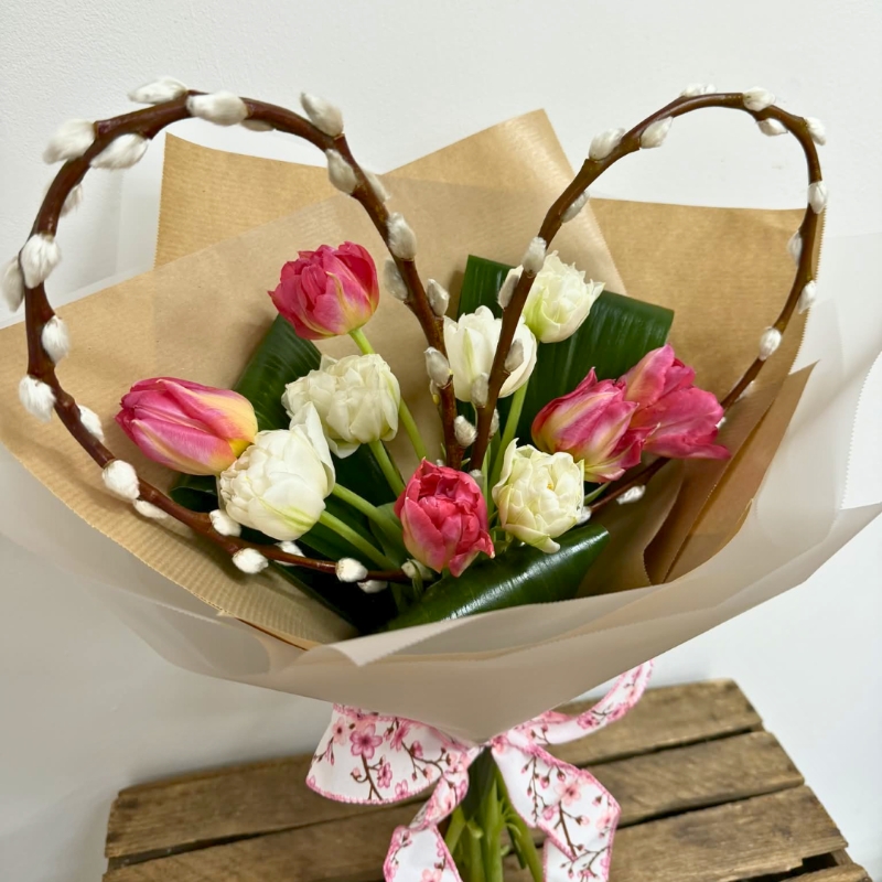 Pink and white tulip bouquet with a handcrafted pussy-willow heart, wrapped in luxury paper and tied with a patterned ribbon.