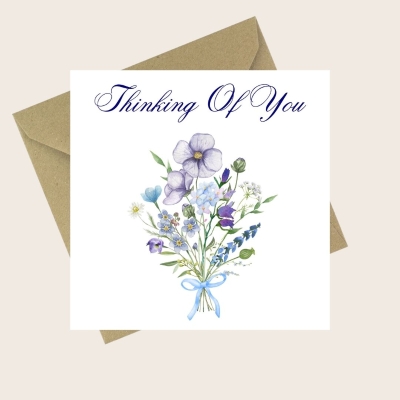 Thinking Of You card with a delicate blue and purple floral bouquet and ribbon.