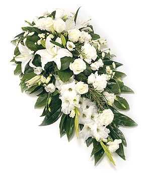 All-white single-ended funeral spray with seasonal flowers and green foliage.