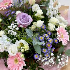 Hand tied bouquet in soft pinks, lilac and white, including roses, stocks, germini, bunny tail and other mixed varieties. 