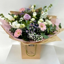 Hand tied bouquet in soft pinks, lilac and white, including roses, stocks, germini, bunny tail and other mixed varieties. 