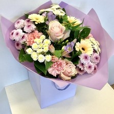 Hand tied bouquet of pastel tones including roses, carnations, chrysanthemums and freesia. 