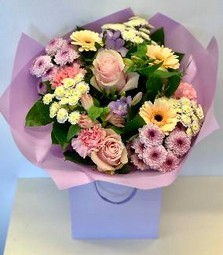 Hand tied bouquet of pastel tones including roses, carnations, chrysanthemums and freesia. 