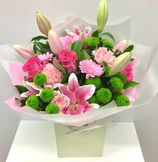 Luxurious bouquet featuring pink roses, pink lilies, pink germini, and lime green chrysanthemums, elegantly wrapped in premium cellophane with a matching gift bag.