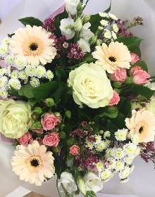 Floral favourites including roses, wax flower, germini and lisianthus in soft tones. 