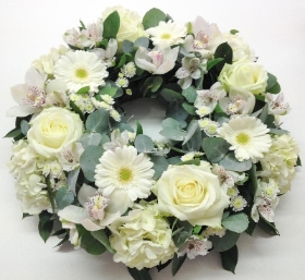 Pure white funeral wreath including roses, carnations and chrysanthemum. 
