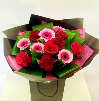 Red roses, red carnations and pink germini gift bouquet.