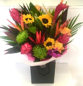 Hand tied in water to include tropical flowers such as ginger, heliconia and sunflowers. 