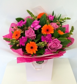 Hand tied of bright pink and tangy orange tones, including roses, germini and snapdragons. 