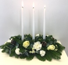 Slim festive arrangement in frosty whites and green with touches of glitter. Finished with 3 tapered candles. 