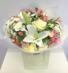 Hand tied bouquet in white and soft pink with touches of copper foliage. 