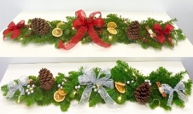 Fresh spruce garland with decorative ribbon, pine cones, cinnamon and orange slices. 