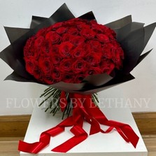 Hand-tied bouquet of 100 luxury large-headed red Freedom roses, wrapped in frosted black cellophane with a large red satin ribbon, and delivered with a FREE XL glass vase. Size: 24 x 24 Inch.