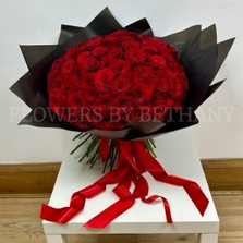 Hand-tied bouquet of 100 luxury large-headed red Freedom roses, wrapped in frosted black cellophane with a large red satin ribbon, and delivered with a FREE XL glass vase. Size: 24 x 24 Inch.
