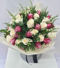 Luxury gift bouquet of lilac and white roses, touches of scented wax flower and presented in a grey hatbox. 