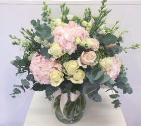 Luxury bouquet of pale pink hydrangea and roses, white rose and lisianthus and finished with eucalyptus and large glass vase. 