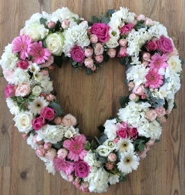 Pale pink and white open heart tribute including roses, germini and hydrangea. 