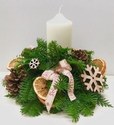 Festive arrangement including decorative wooden accents, sliced oranges and pine cones. 