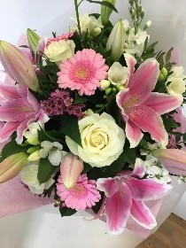 Luxury hat box bouquet including mixed pink tones. Scented flowers such as roses, lily, wax flower and freesia. 