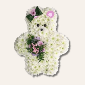 Teddy bear funeral tribute with white chrysanthemums, pink focal florals and a hair bow made of folded leaf. 