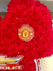 Manchester United football shirt funeral tribute created with chrysanthemum and waterproof badges and logos. 