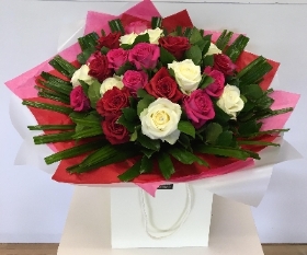 Luxury fusion of 24 pink, red and white roses, hand tied in water. 