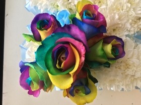 Rainbow focal MUM funeral tribute with white chrysanthemum base. 