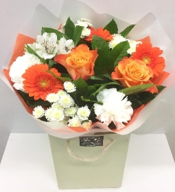 Orange and white flowers in a mixed bouquet including roses, germini and carnation. 