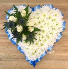 Blue heart funeral tribute with white rose and blue thistle focal. 