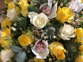 Mixed sunny yellow funeral posy tribute including roses, orchids and hypericum berries. 