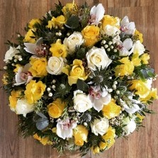 Mixed sunny yellow funeral posy tribute including roses, orchids and hypericum berries. 