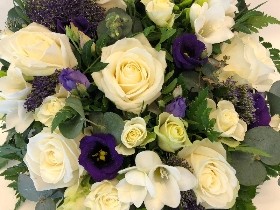 Violet and white funeral posy with mixed seasonal flowers and eucalyptus foliage for a fresh, natural finish