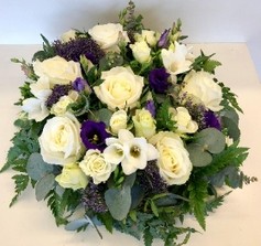 Mixed violet and white funeral posy in mixed seasonal flowers. 