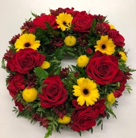 United wreath funeral tribute in red and yellow tones. 