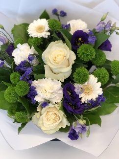 Hand tied bouquet including mondial white roses, purple Lizianthus, Kermit chrysanthemum and a mix of other fresh toned flowers. 
