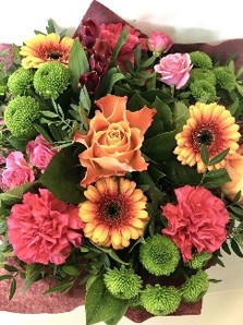 Hand tied in deep orange and pink tones, Including roses, carnations, chrysanthemums and germini. 