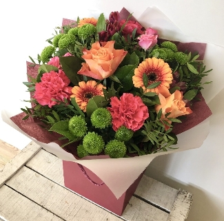 Hand tied in deep orange and pink tones, Including roses, carnations, chrysanthemums and germini. 