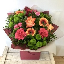Hand tied in deep orange and pink tones, Including roses, carnations, chrysanthemums and germini. 