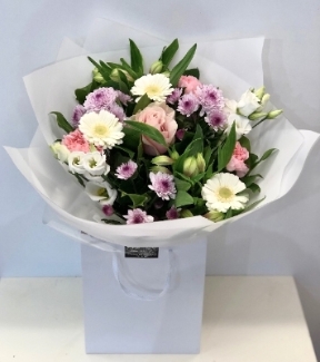 Hand tied bouquet of soft tones, includes roses, carnation, chrysanthemums and germini. 