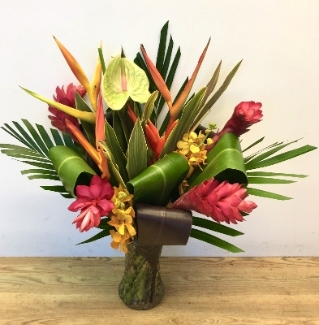 Eco friendly hand tied of tropical flowers comes in glass vase. 