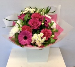 Bright bouquet in cerise and white including roses, gerbera, carnation and chrysanthemums. Hand tied in water.