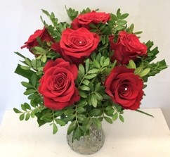 Red rose bouquet displayed in a glass vase with zero plastic. 