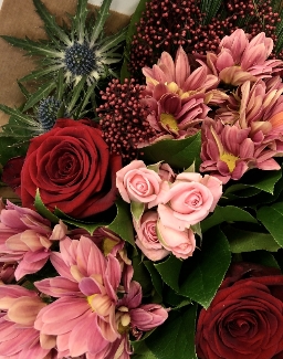 This bouquet is stylish with tones of red and pink. Including roses, berries and thistle. 
